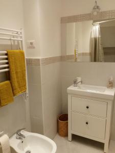 une salle de bains blanche avec un lavabo et un miroir dans l'établissement Casa del Cioccolatte, à Gênes