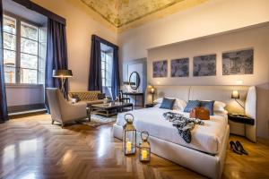 a bedroom with a large bed and a living room at Palazzo Ridolfi - Residenza d'Epoca in Florence