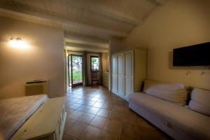 モーディカにあるNacalino Agriturismoのベッド2台、壁掛けテレビが備わる客室です。