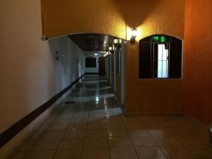 un couloir vide dans un bâtiment aux murs orange dans l'établissement Pousada Fonseca, à Itanhaém