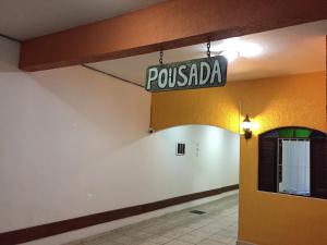 ein Schild, das sagt, die Pousada hängt von einem Gebäude in der Unterkunft Pousada Fonseca in Itanhaém