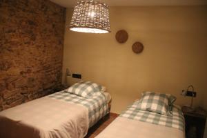 1 Schlafzimmer mit 2 Betten und einem Kronleuchter in der Unterkunft El Baluard in Cardona
