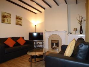 a living room with a couch and a fireplace at Loscoe House in Codnor