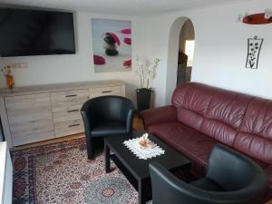 een woonkamer met een bank, stoelen en een tafel bij Ferienhaus Richter in Bad Schandau