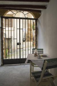 mesa y sillas en una habitación con puerta en Barone Apartments, en Sciacca