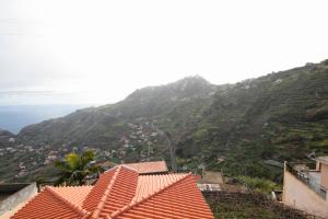 vistas a una montaña con casas y al océano en Lobos Rustic House II, en Câmara de Lobos