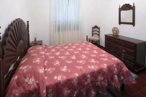 1 dormitorio con cama roja y vestidor en Lobos Rustic House II, en Câmara de Lobos