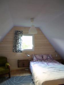a small bedroom with a bed and a window at Domek nad jeziorem Kątno Mazury in Kątno