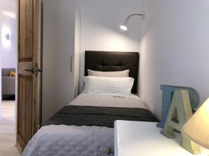 a small bedroom with a bed in a room at Apartaments La Palmera, Terrace & Pool in Sant Martí d'Empúries