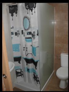 a bathroom with a shower curtain and a toilet at Habitacions Casa Roberto in Ontinyent
