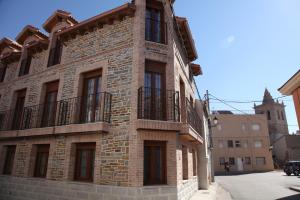 a brick building with balconies on the side of it at Casa Rural La Fragua in Guadalix de la Sierra