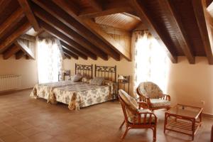 una camera da letto con un letto grande e una sedia di Casa Rural La Fragua a Guadalix de la Sierra Altre 5 foto