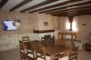 a dining room with a table and chairs and a tv at Casa Rural La Fragua in Guadalix de la Sierra