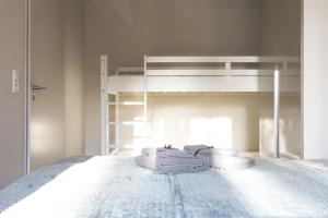 a bed with towels and bunk beds in a room at KUKU Urban & Family Appartement in Dresden