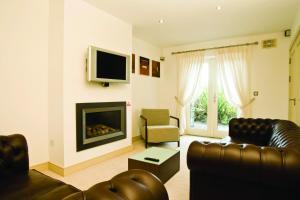 a living room with a couch and a fireplace at Ring of Kerry Holiday Cottages No 22 by Trident Holiday Homes in Kenmare