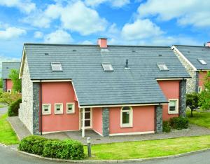 ein rotes Haus mit schwarzem Dach in der Unterkunft Ring of Kerry Holiday Cottages No 22 in Kenmare