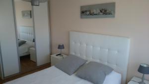 a bedroom with a white bed and a mirror at la palme d or in Saint-Raphaël