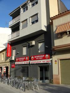 a building with a bunch of chairs in front of it at Habitacions Casa Roberto in Ontinyent