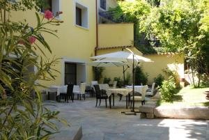 a patio with tables and chairs and an umbrella at Au Lavoir in Colombiers