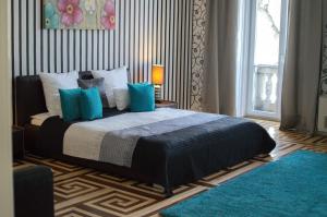 a bedroom with a large bed with blue pillows at Harmonia Palace in Budapest