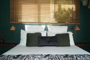 a large bed with white pillows and a window at Waitapu Springs B&B in Takaka