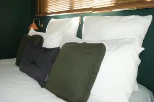 ein Bett mit weißen Kissen und einer grünen Wand in der Unterkunft Waitapu Springs B&B in Takaka