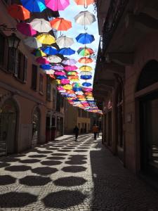 a row of colorful umbrellas hanging from an alley at Casa Corte Alla Rocca in Arona