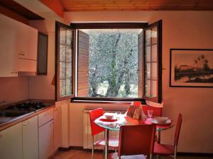 a kitchen with a table with chairs and a window at casa caberlon in Malcesine