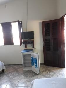 Habitación con cama, ordenador y puerta en Pousada Aconchego, en Mundaú