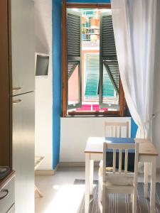 a kitchen with a table and a window at La Polena Camere Vernazza - Visconti Apartment in Vernazza