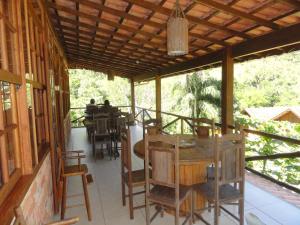 a patio with a table and chairs on a house at Pousada Chácara do Rio in Lumiar