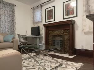 a living room with a fireplace and a glass table at Ambassador's Inn Next Door in Stratford