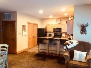 a kitchen and living room with a stove top oven at Boyne Mountain Creekside Condo in Boyne Falls