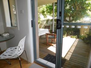 a sliding glass door to a patio with a table and chairs at Beachport Bed & Breakfast in Port Macquarie