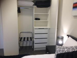 1 dormitorio con armario, cama y silla en Crow's Nest, en Picton