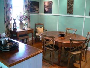 een eetkamer met een houten tafel en stoelen bij Lemon Tree Cottage in Leura