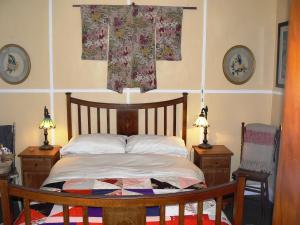 een slaapkamer met een bed en twee tafels en twee lampen bij Lemon Tree Cottage in Leura