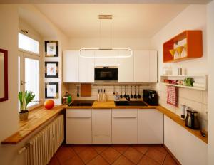 uma cozinha com armários brancos e um lavatório em Neustadt - Paradies em Dresden