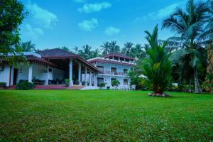 a house with a lawn in front of it at Waterside Bentota in Bentota