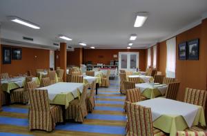 a dining room with tables and chairs in a room at AHC Hoteles Cáceres in Cáceres