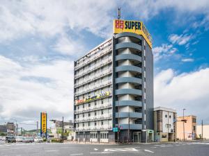 a building with a sign on the top of it at Natural Hot Spring Super Hotel Tottori Eki Kitaguchi in Tottori