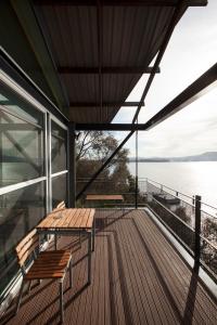 a deck with two benches and a view of the water at MONA Pavilions in Hobart