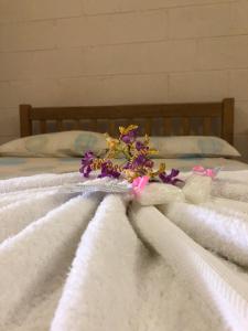 a bouquet of flowers sitting on top of a bed at Access Units in Lungga