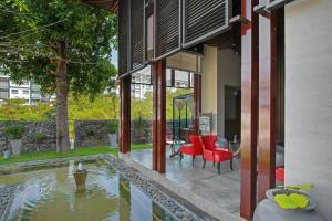 a house with a swimming pool and red chairs next to a house at The Serenity Hua Hin in Hua Hin