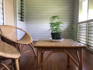 a table and two chairs and a potted plant on a porch at Access Units in Lungga