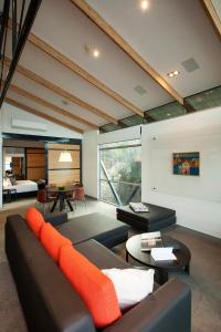 a living room with a couch and tables and a bedroom at MONA Pavilions in Hobart
