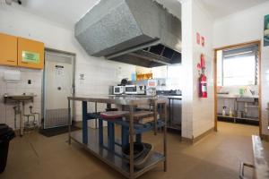 a kitchen with a stove top oven and a counter top at Coolangatta YHA Backpackers in Gold Coast