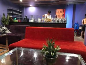 a red couch in a room with a bar at Bamboo Green Riverside Hotel in Danang