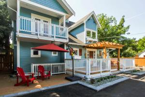 Casa con patio con sillas rojas y sombrilla en Kelowna Bed & Breakfast - CHATHAM HOUSE, en Kelowna