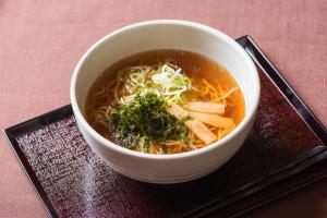 una ciotola di zuppa su un piatto su un tavolo di Dormy Inn Sendai Annex a Sendai